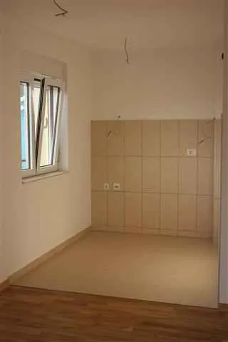 Empty room intended for a kitchen with ceramic tiles and a window.