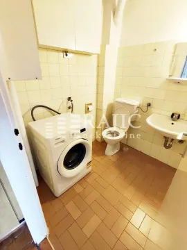 Smaller bathroom with sanitary facilities and a washing machine. - image 19