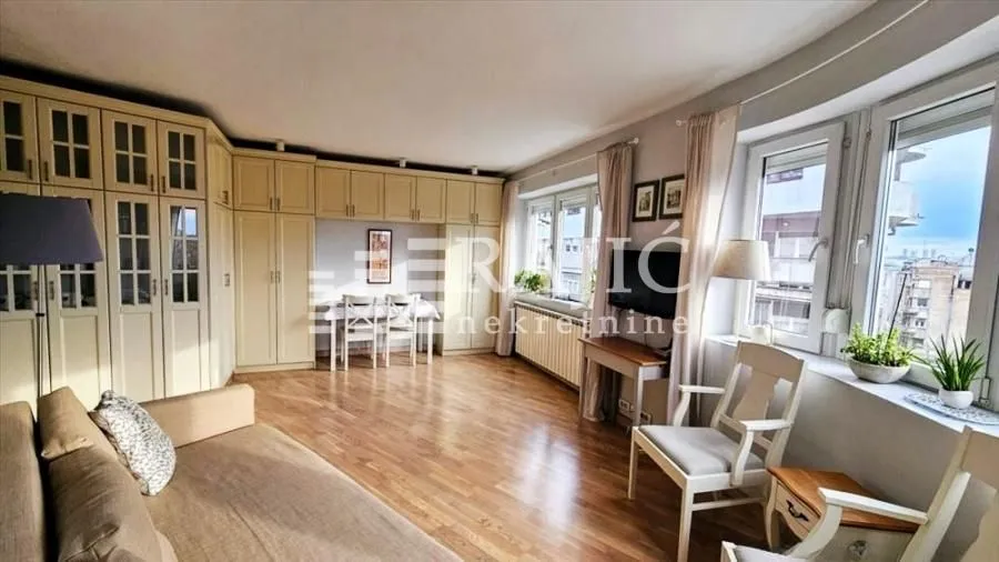 Spacious living room with a sofa set, dining table, and built-in closets.