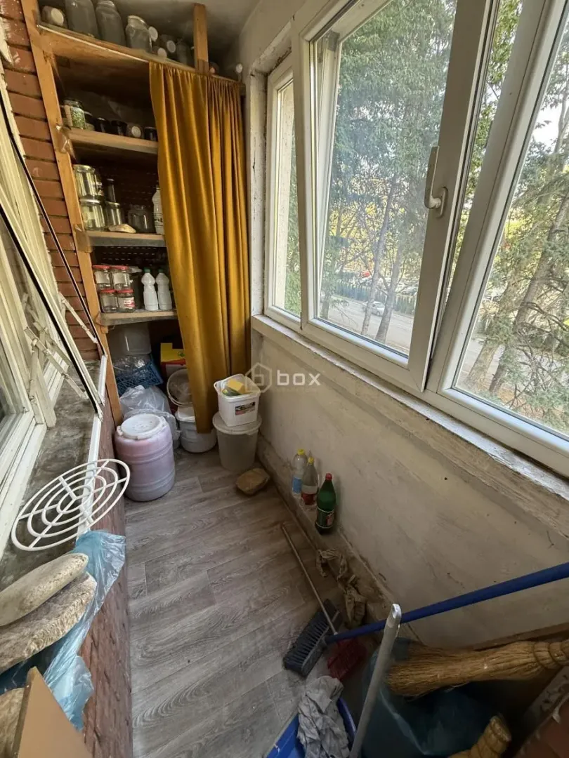 Zastakljeni balkon sa policama za odlaganje stvari.