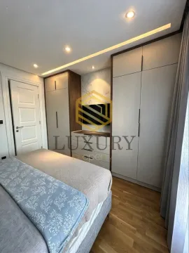 Moderna spavaća soba sa bračnim krevetom, ugradnim plakarima i TV-om. - image 3