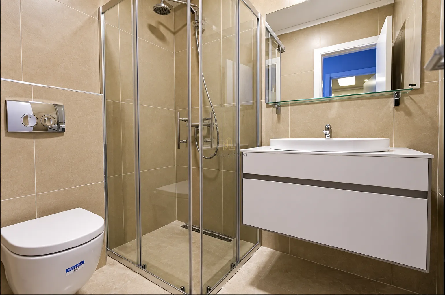 Modernly equipped bathroom with a shower cabin, washbasin, and toilet.