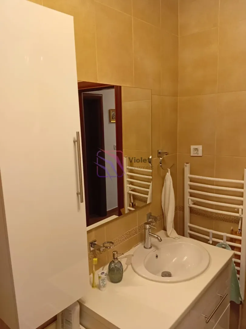 Kupatilo sa umivaonikom, ogledalom i ormarićem.