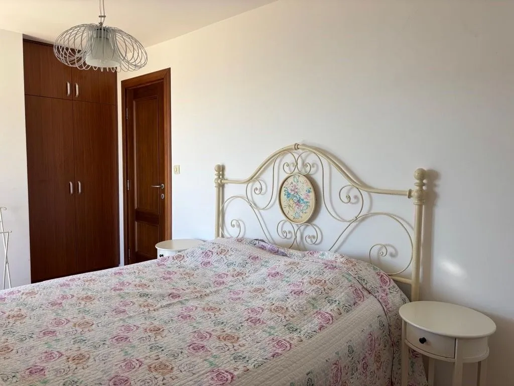 Spavaća soba sa bračnim krevetom, ugradnim ormarom i noćnim stočićima.