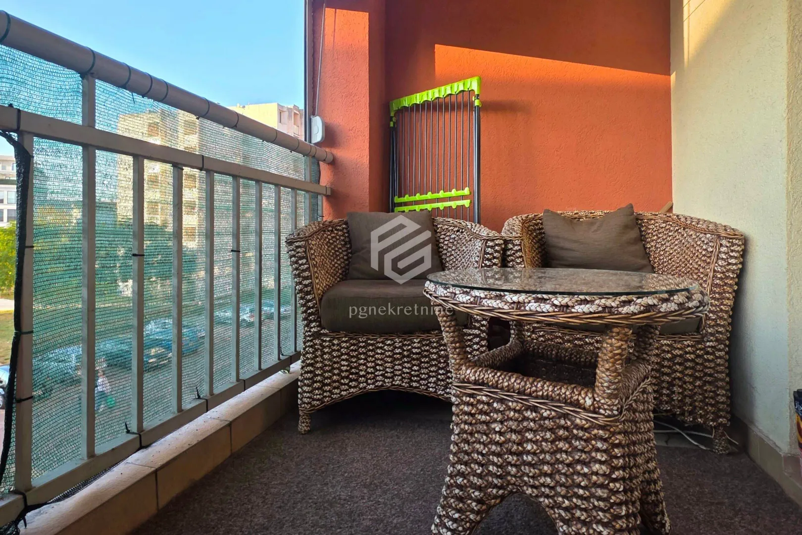 Namješten balkon sa pletenim foteljama i stočićem.