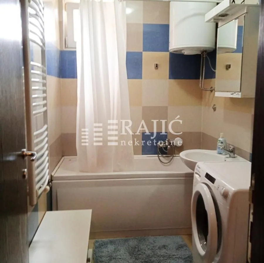 Small bathroom with a bathtub, sink, and washing machine.