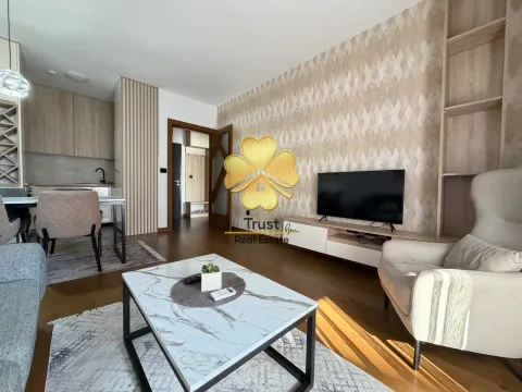 Modern living room with a sofa, TV, and dining area in the background. - image 3