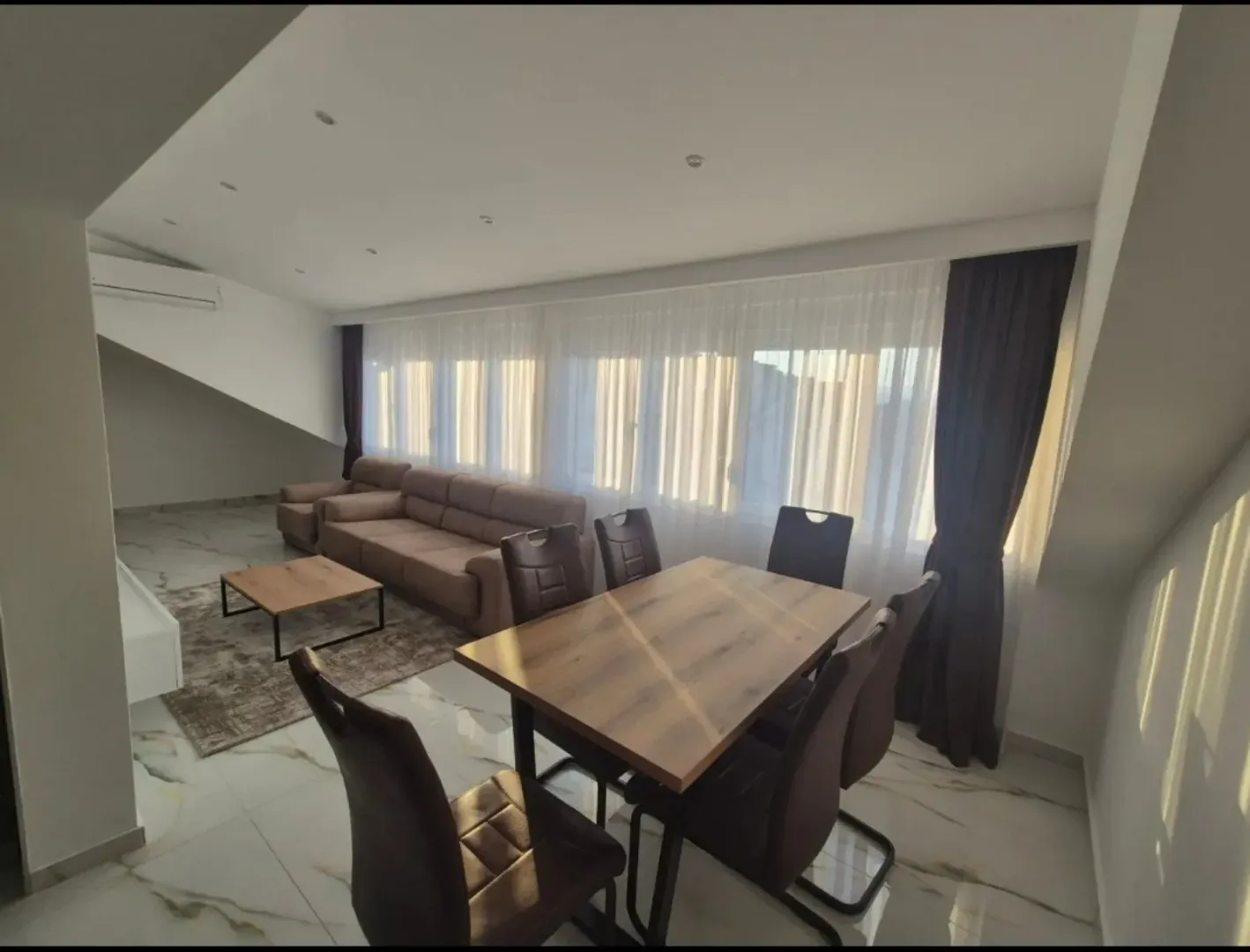 Spacious living room with a seating set and a dining table.