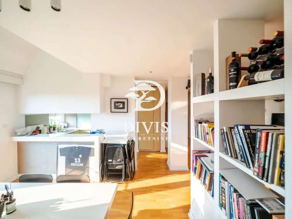 Living room with bookshelves and a view of the kitchen.