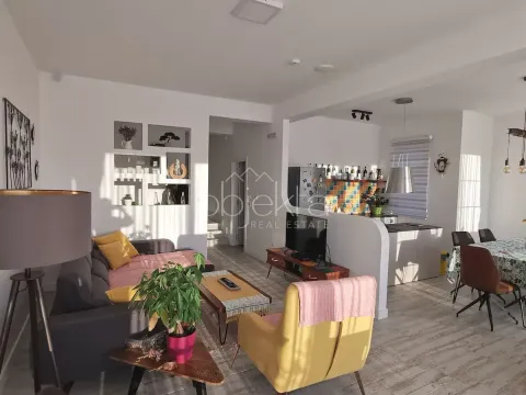 Open-plan living room with kitchen and dining area. - image 4