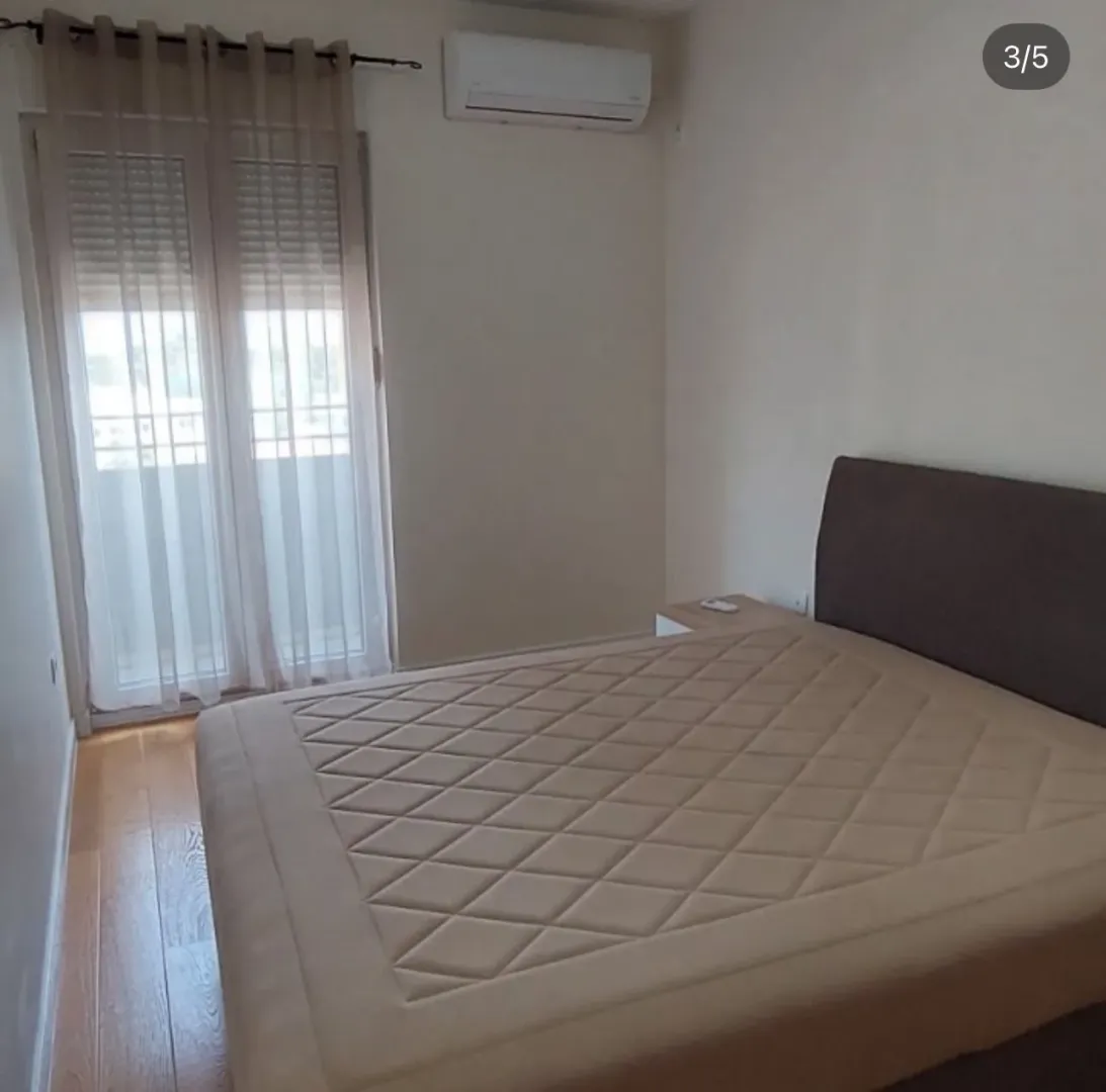 Bedroom with a double bed, air conditioning, and balcony access.