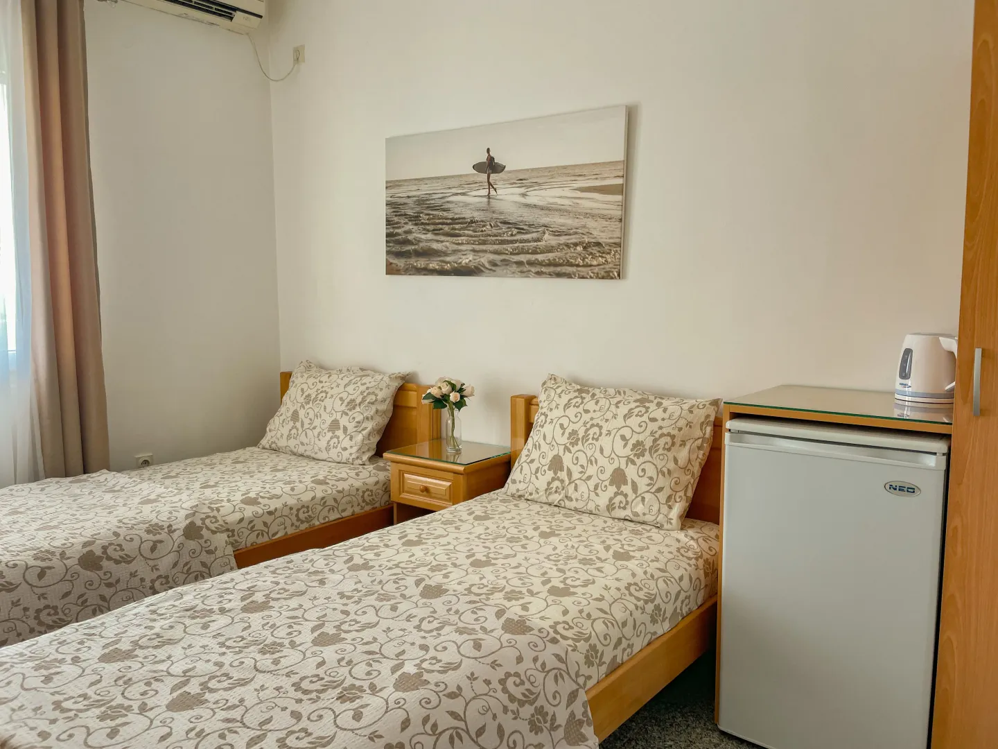 Bedroom with two single beds and a small refrigerator.
