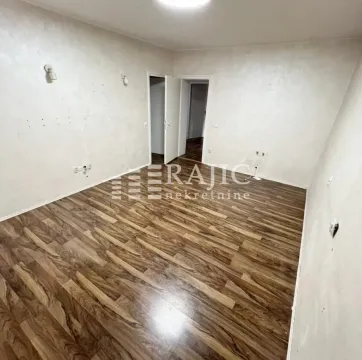 Empty room with laminate flooring and light-colored walls. - image 2