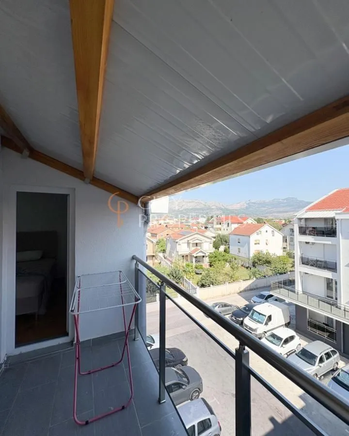 Covered balcony with a view of the neighborhood and parking lot.