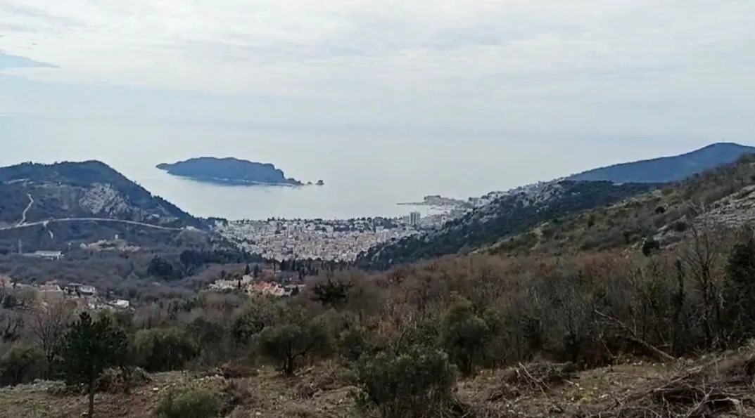 Pogled sa imanja na more i grad u daljini.