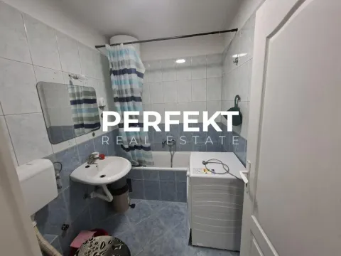 Kupatilo obloženo pločicama sa kadom, umivaonikom i veš mašinom. - image 16