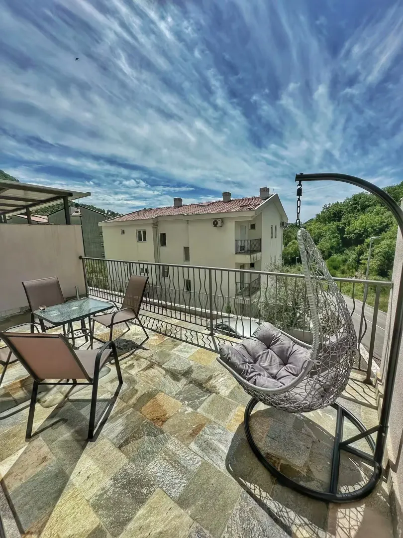 Furnished terrace with seating furniture and a swing chair.