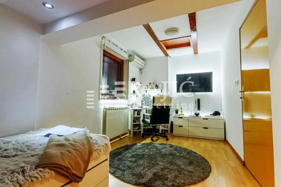 Furnished bedroom with a desk and TV.