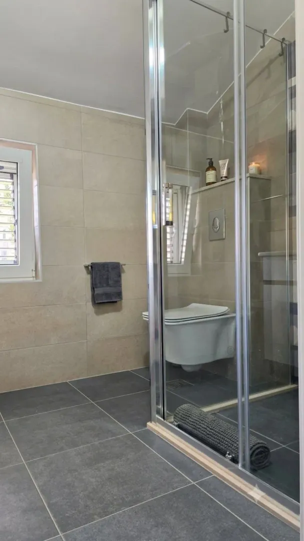 A modern bathroom equipped with a shower cabin and sanitary ware.
