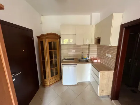 Small kitchen with light-colored cabinets and a wooden display cabinet. - image 3