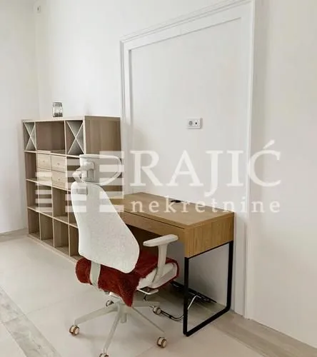 Work corner with a desk, chair, and shelving unit in the room.