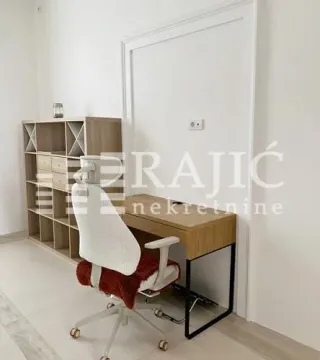 Work corner with a desk, chair, and shelving unit in the room. - image 3