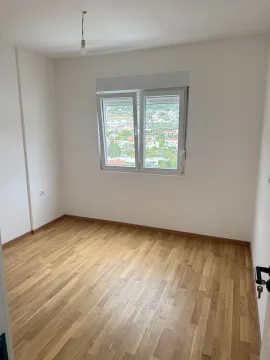 Empty room with white walls, parquet flooring, and a window view. - image 12