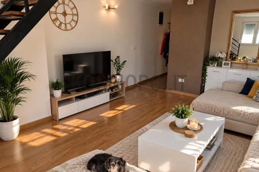 Living room with a TV, sofa, and staircase.