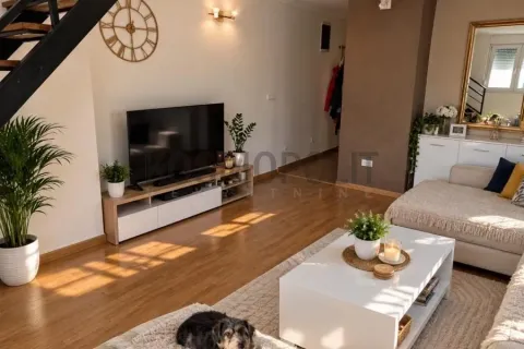 Living room with a TV, sofa, and staircase. - image 3
