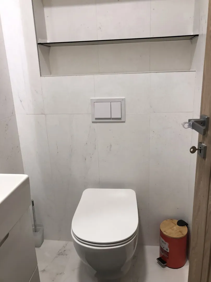 Modern toilet with white tiles.