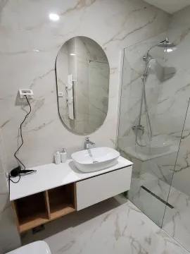 Modern bathroom equipped with a washbasin and a walk-in shower. - image 11