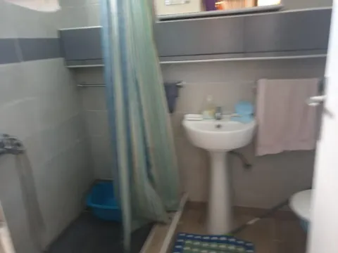 Manje kupatilo sa umivaonikom, tuš kabinom sa zavesom i zidnim elementima. - image 2