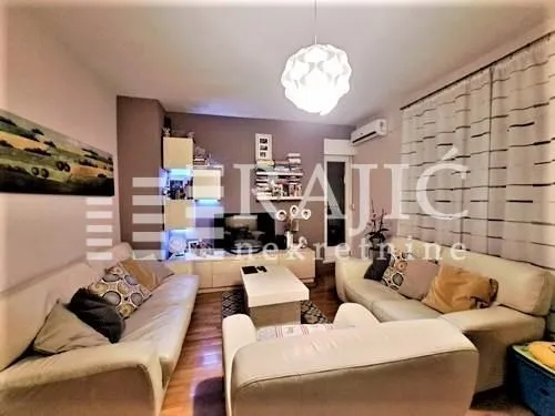 Spacious living room furnished with a seating set and a TV unit.