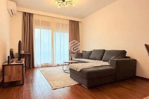 Dnevna soba sa ugaonom garniturom, TV komodom i izlazom na balkon. - image 2