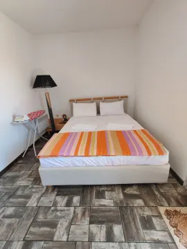 Spavaća soba sa bračnim krevetom, lampom i daskom za peglanje. - image 14