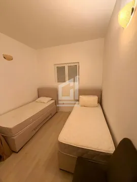 Manja spavaća soba sa dva odvojena kreveta i prozorom. - image 6