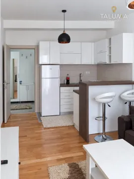 Small kitchen with white cabinets, a breakfast bar and bar stools. - image 2