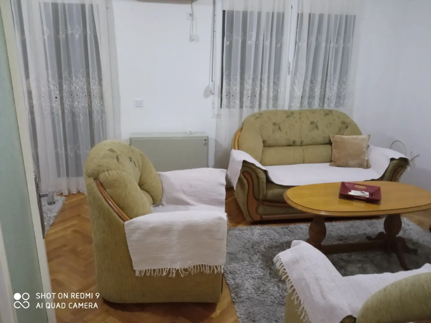 A living room with a seating set and a wooden coffee table.