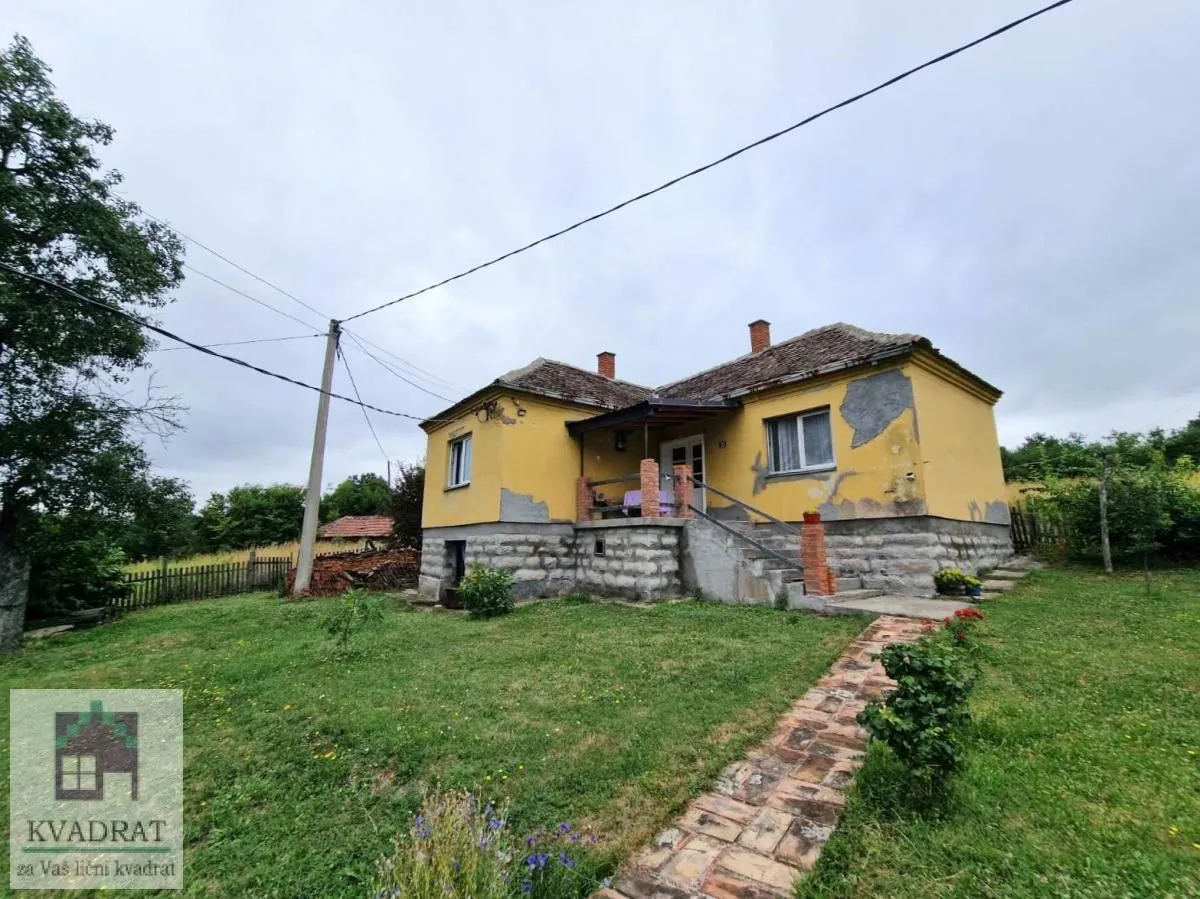 Pogled na stariju prizemnu kuću sa dvorištem i stazom.