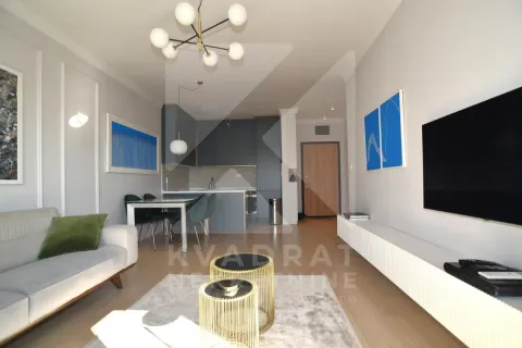 Living room with sofa, TV, and an adjoining dining area. - image 2