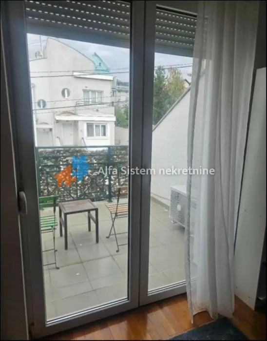 View through balcony doors onto the terrace with outdoor furniture.