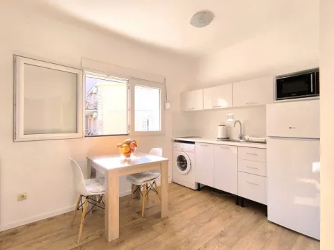 Small bright kitchen with a dining table and white cabinetry. - image 4