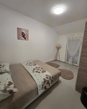 Uređena spavaća soba sa bračnim krevetom i detaljima u enterijeru. - image 6