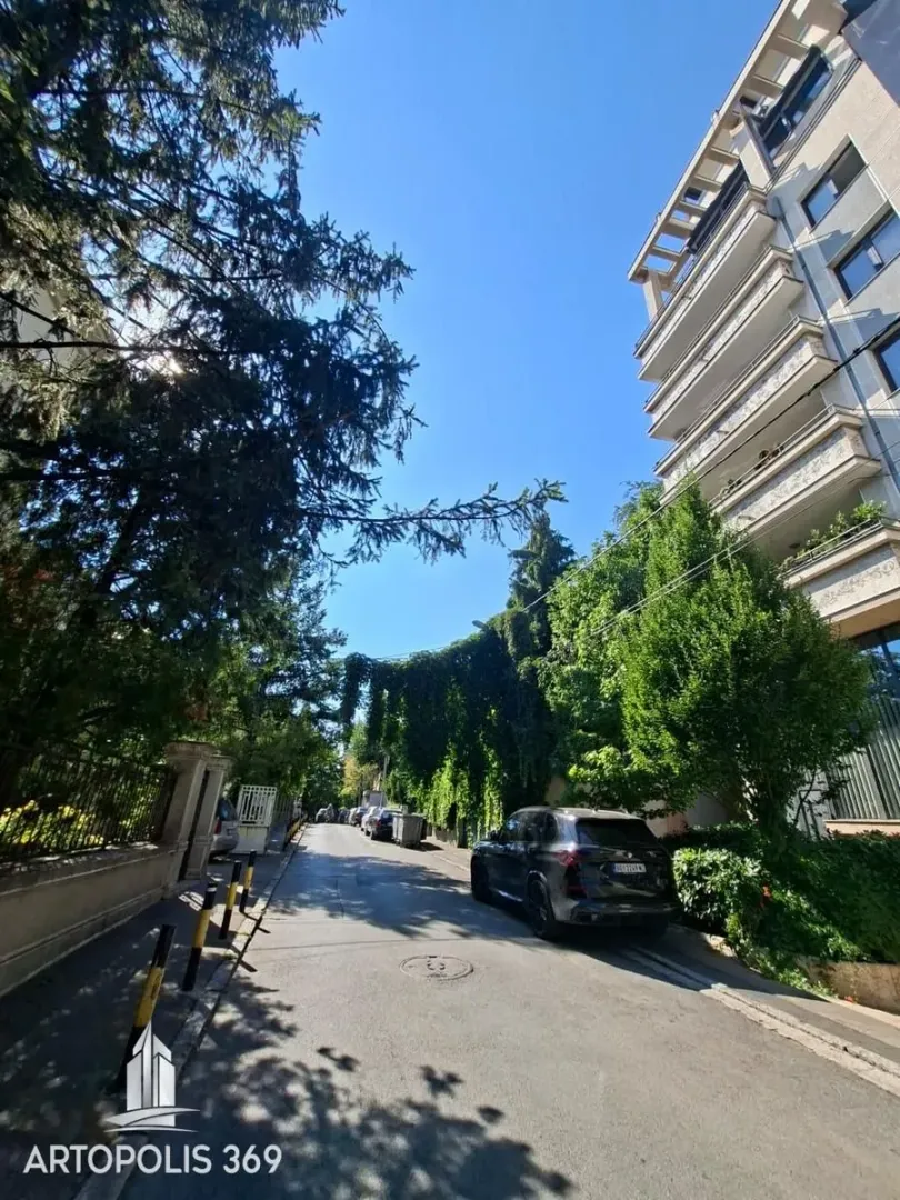Pogled na ulicu i zgradu sa zelenilom.
