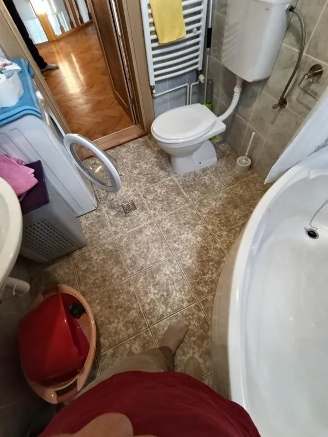 Pogled odozgo na kupatilo sa kadom, toaletom i veš mašinom.