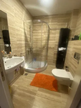 Kupatilo sa tuš kabinom, lavaboom i toaletom u bež tonovima. - image 17