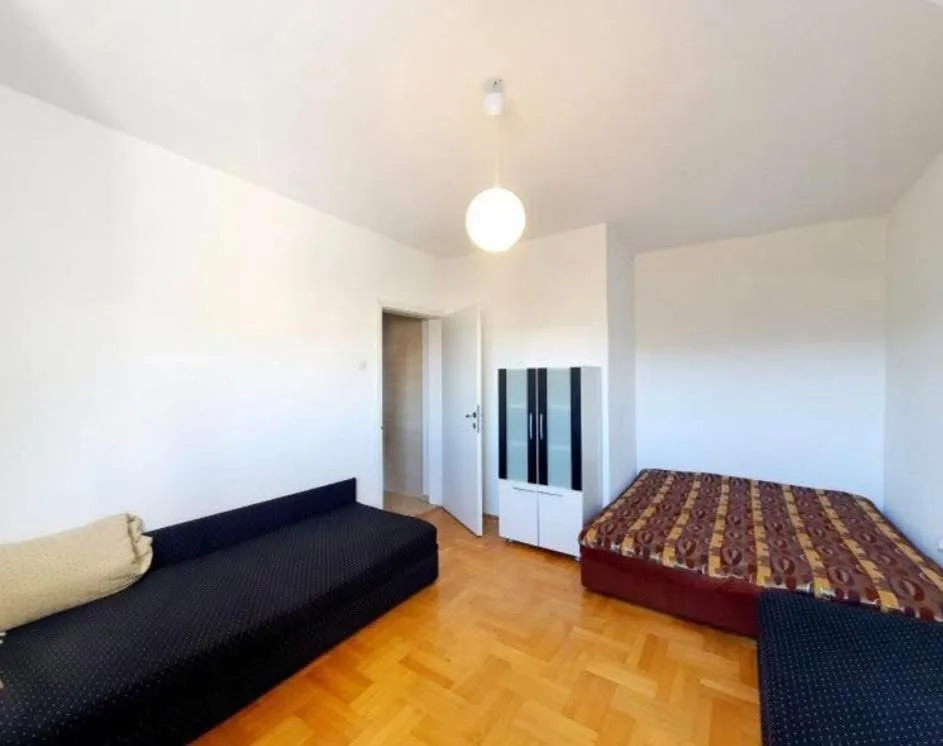 Furnished bedroom with a bed, a sofa bed, and a wardrobe.