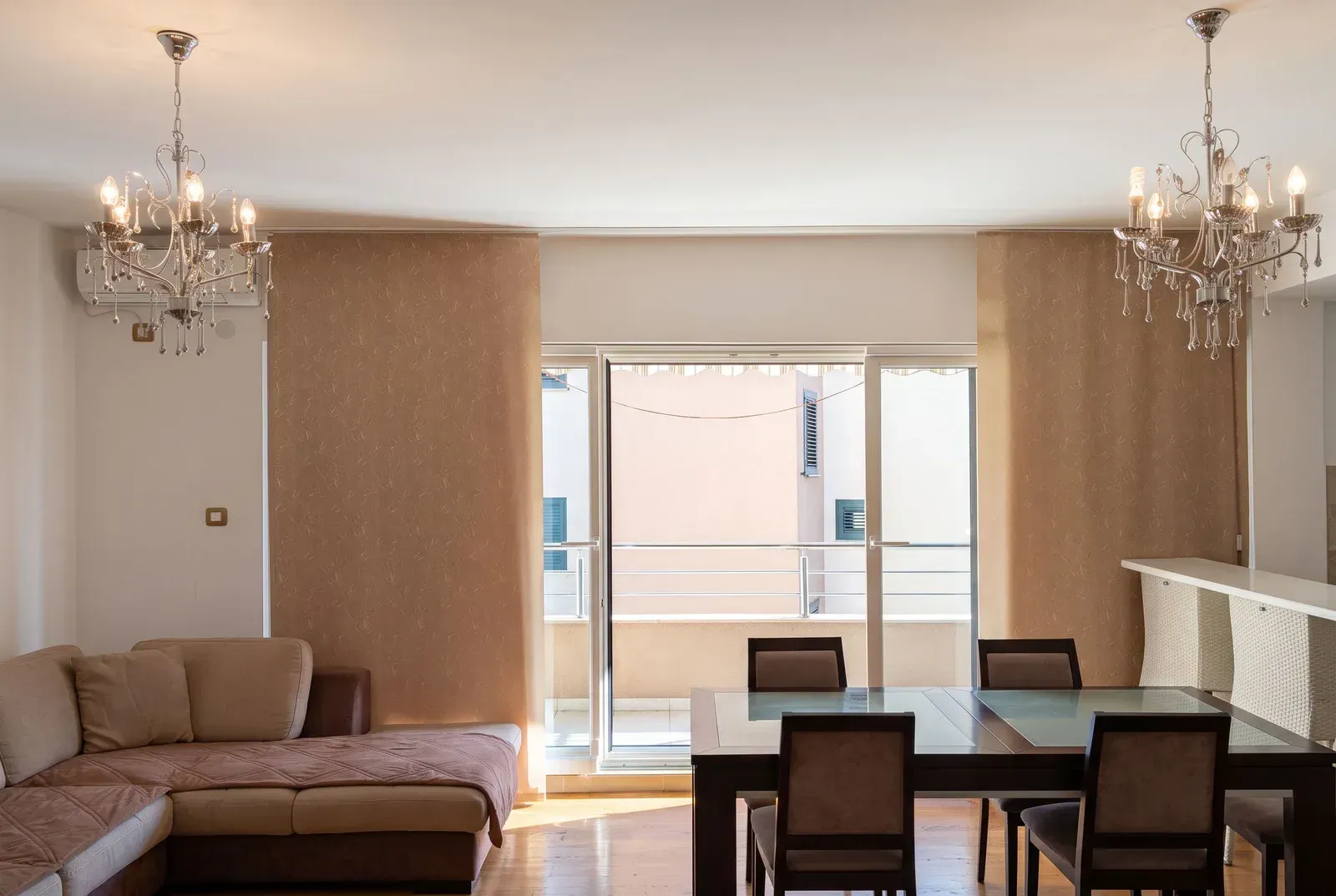 Spacious living room with a sofa set, dining area, and access to the terrace.