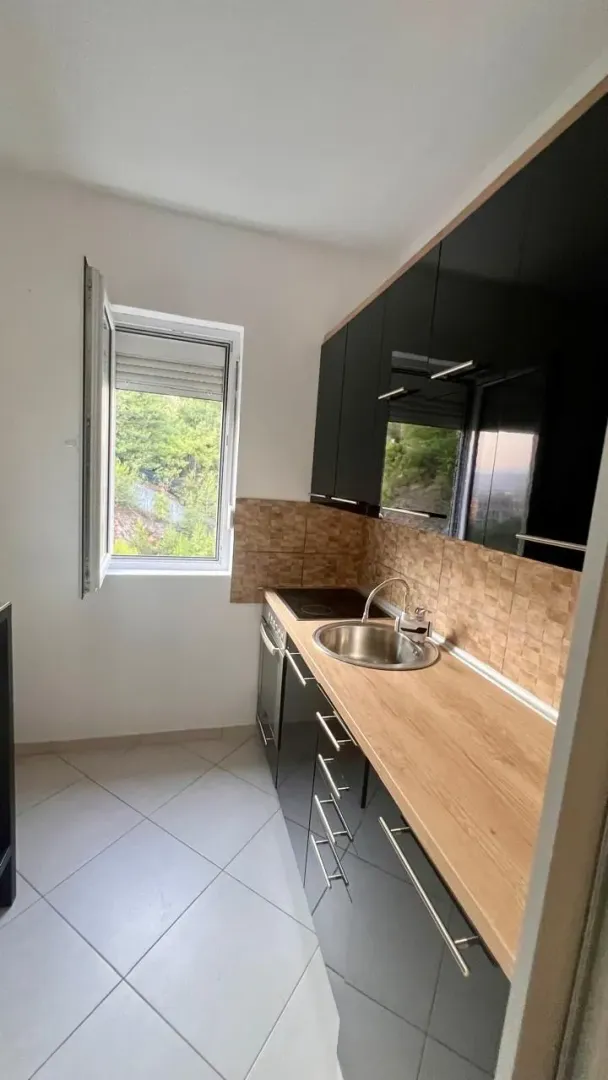 Small kitchen with black cabinets and a wooden countertop.