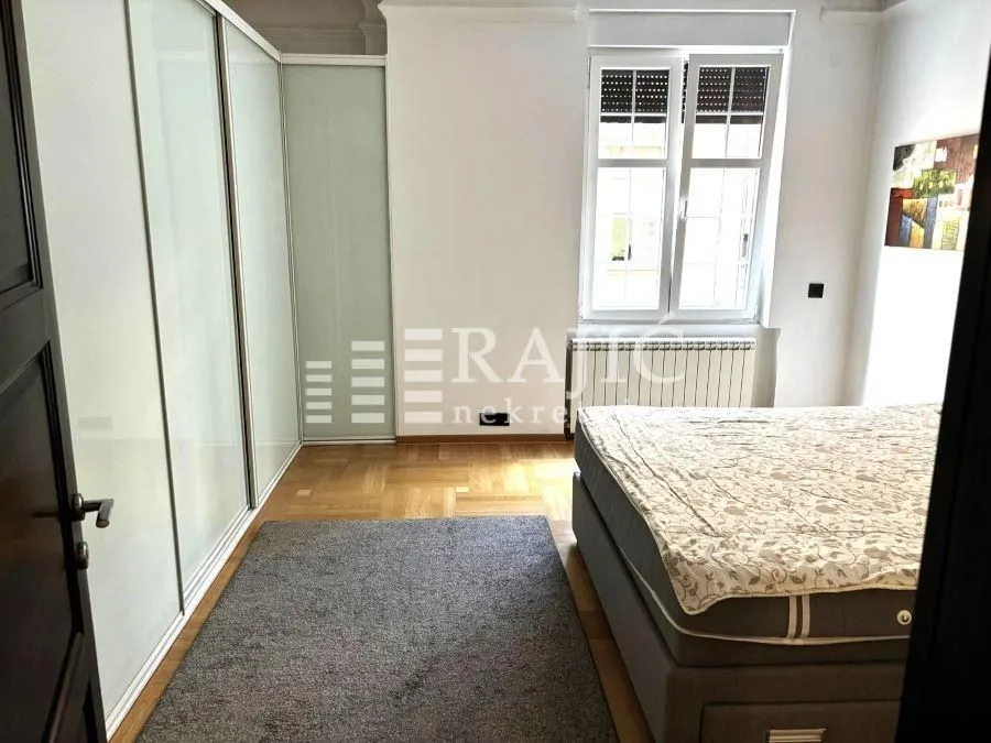 Bedroom with a large double bed, wardrobe, and window.